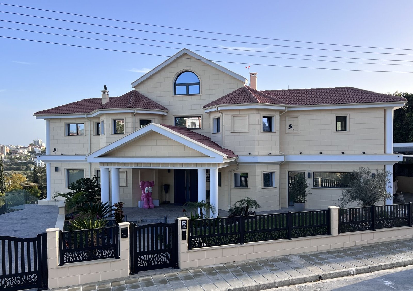 Garden Villa — front façade with mature gardens in daylight