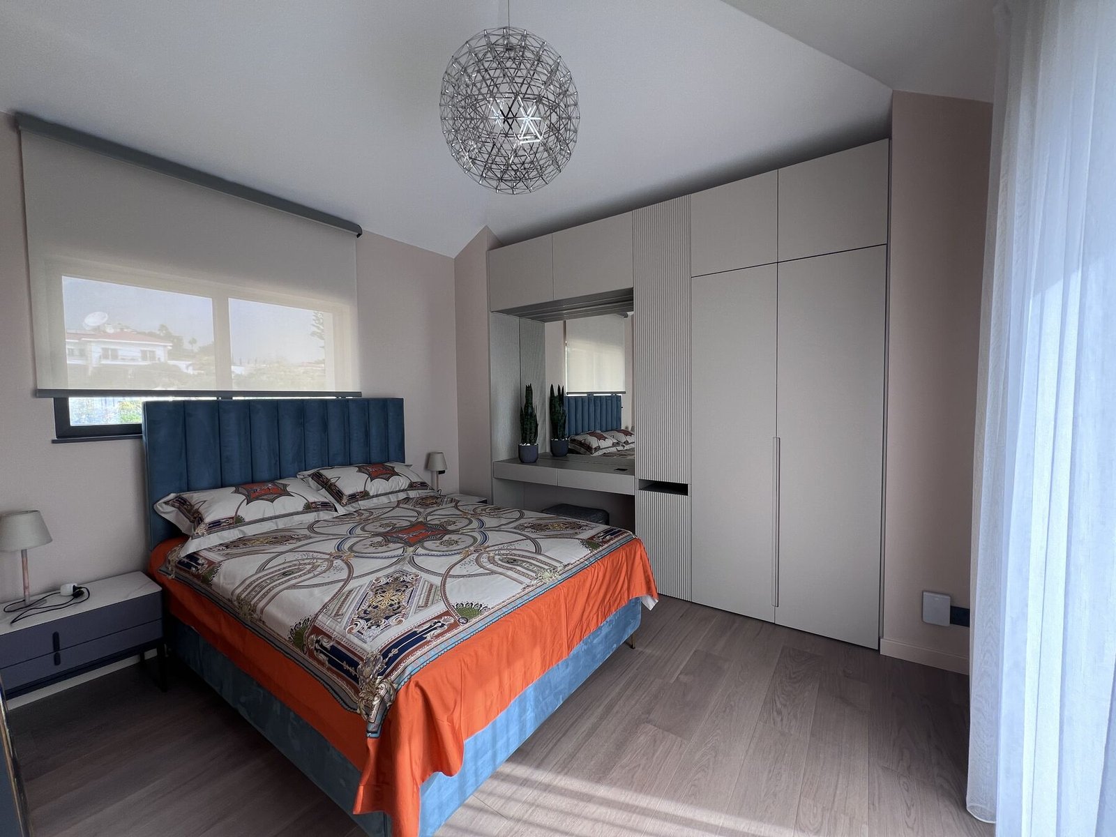 Bedroom with warm orange bedspread and natural light