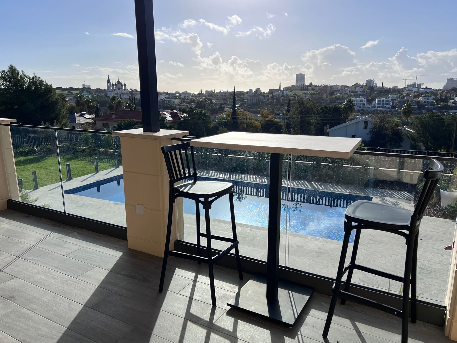 Bar-height table on the terrace overlooking the pool and garden in the morning